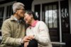 Senior Asian couple embracing in front of home