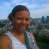 Smiling young Black woman with braided hair in a bun