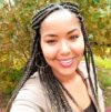 Headshot of Katelyn Provo, a smiling Black woman with long braided hair