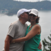 BJ Doyle kisses his wife Judy on the cheek, against a backdrop of the mountains