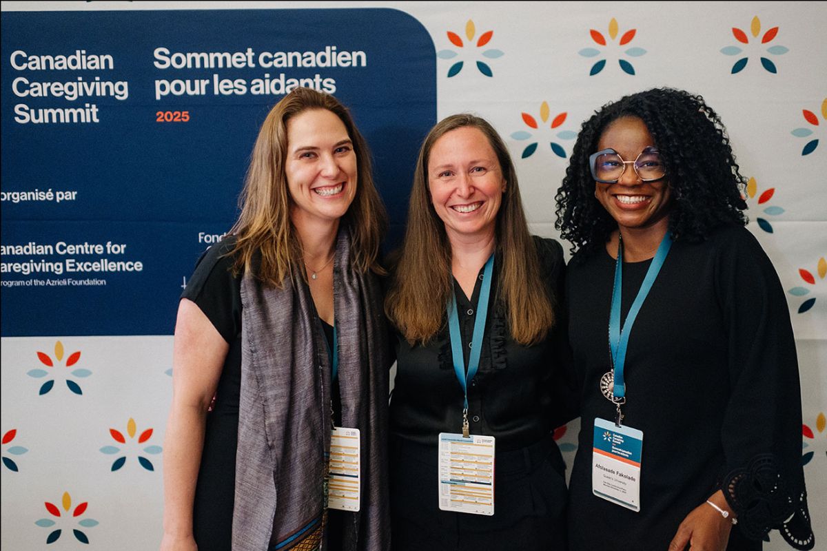 Researchers from Queen's University posing in front of a step and repeat at the Summit