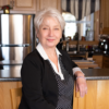 Pamela Barkhouse, an older white woman with short white hair standing in her kitchen